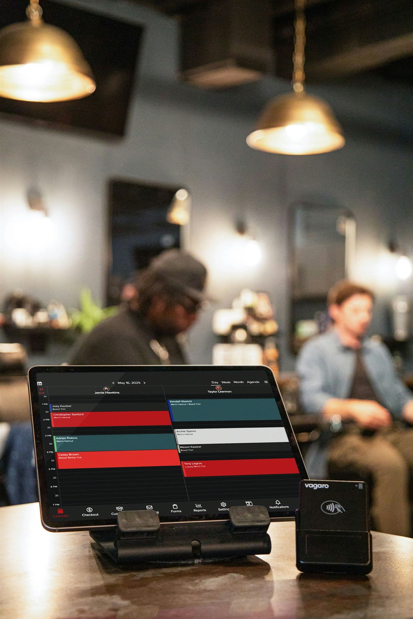 A live appointment calendar and payment terminal inside an active barbershop